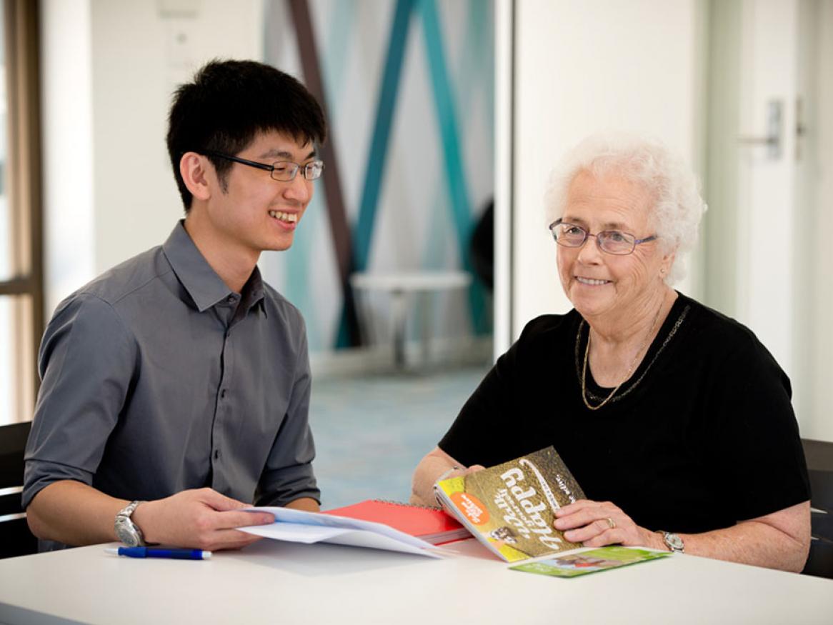 Medial student reading a pamphlet with an older person