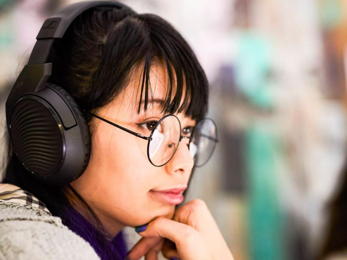 student with headphones looking at computer