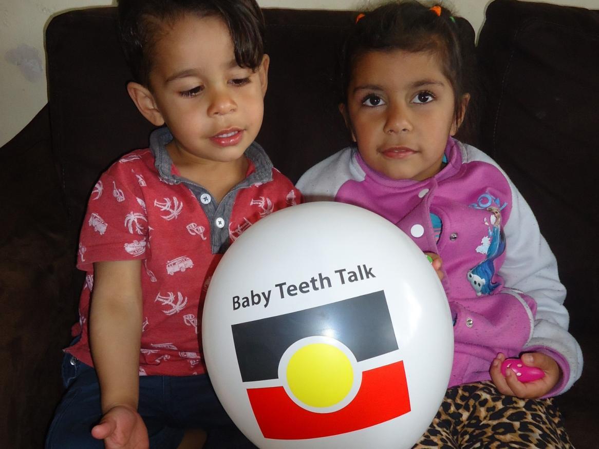Indigenous children with "Baby Teeth Talk" balloon