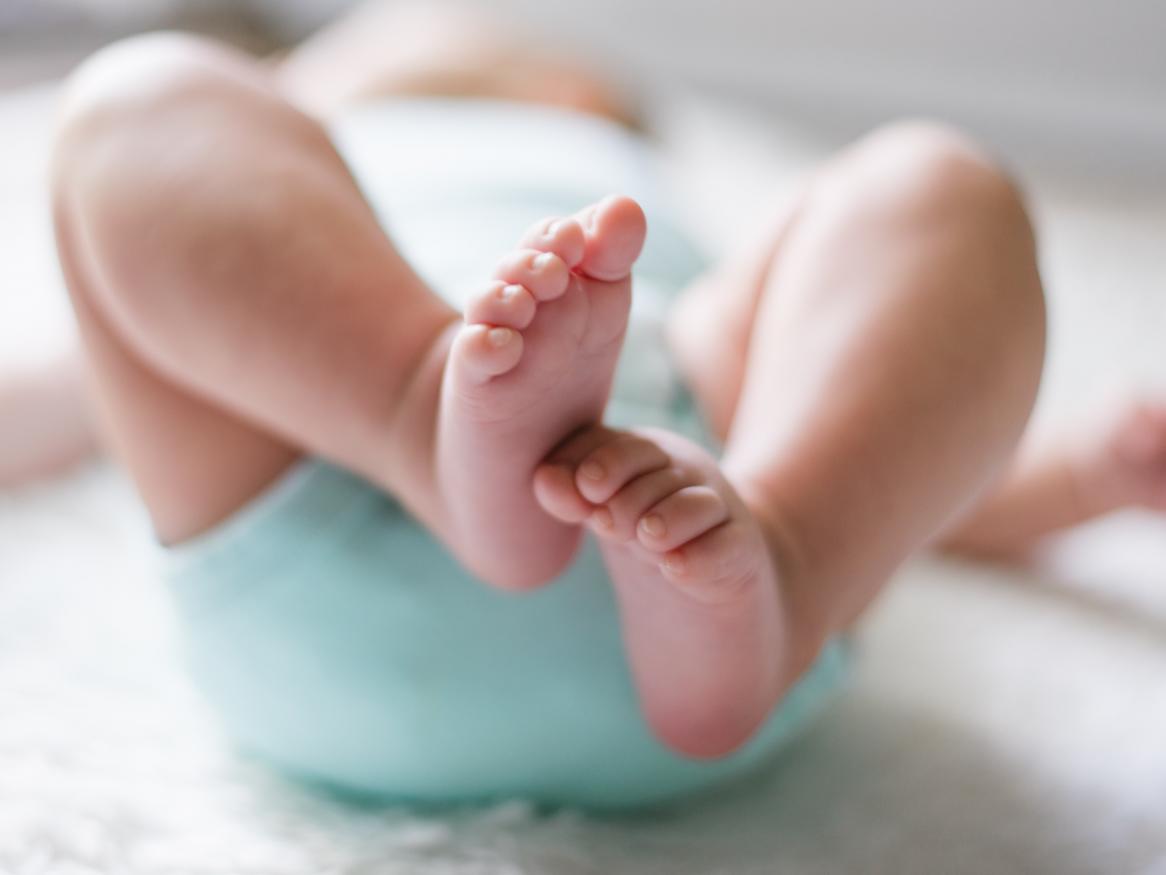 infant lying on back with feet in focus