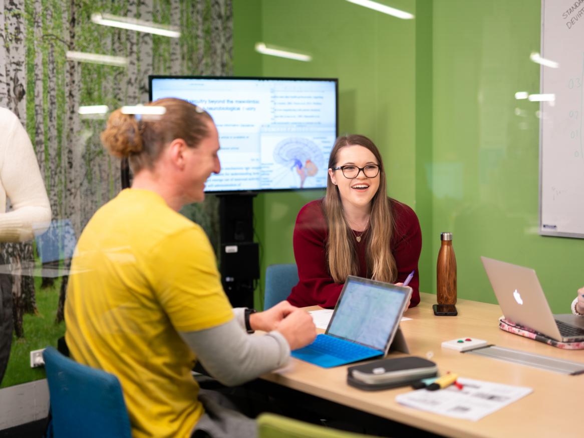 Student study group in meeting room with green walls