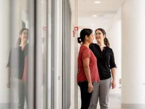 Female participant having height measured by female researcher in corridor