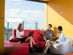 Three students sitting on couches in student space at the Adelaide Health and Medical Sciences building