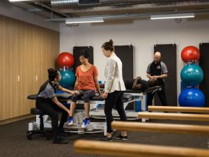 Image of physio student examining patient in rehab gym