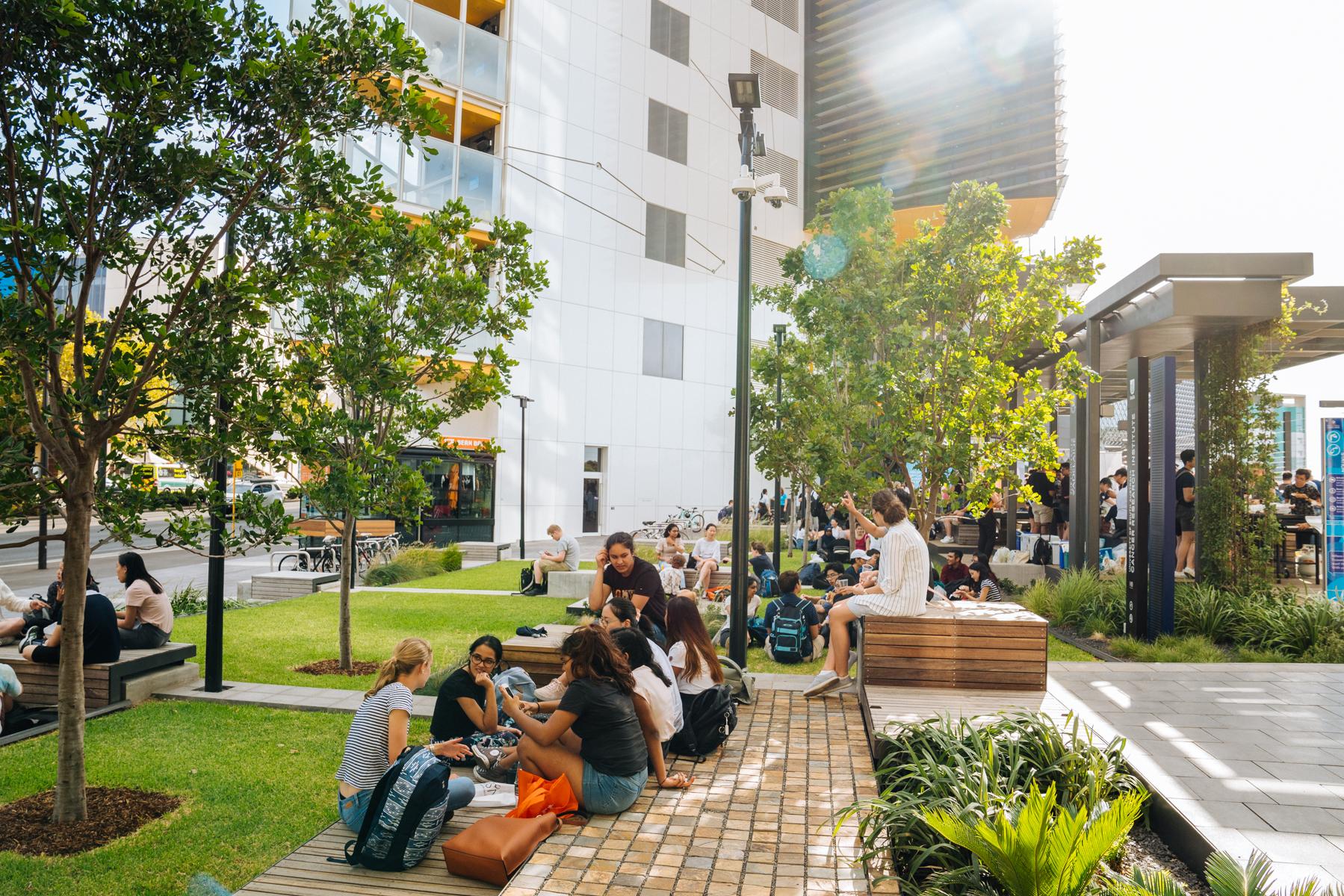 Students sitting and chatting in the Urban Park, outside the AHMS building