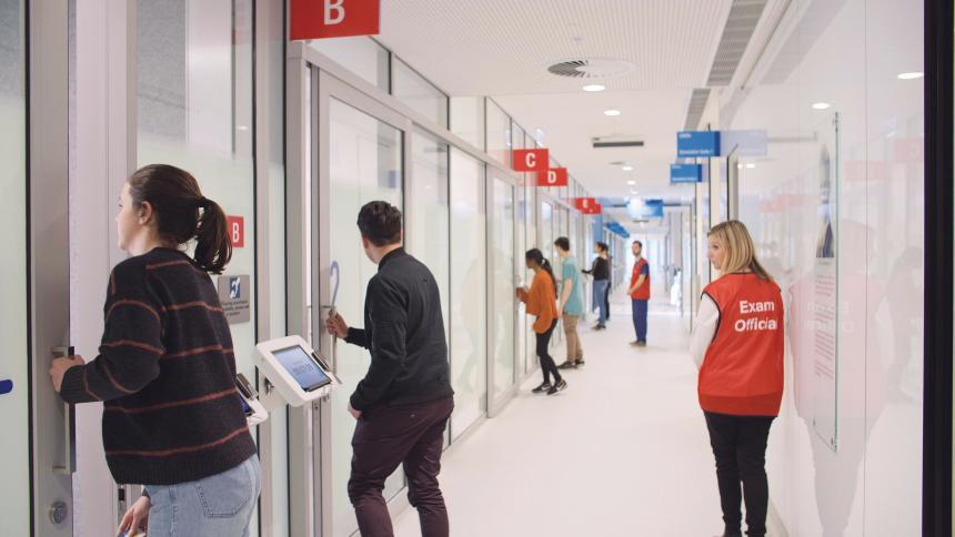 The commencement of an OSCE - students lined up outside exam room with exam marshall monitoring the corridor