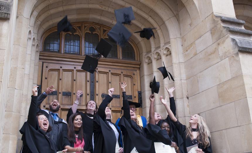 graduations throwing caps into the air after graduation ceremony, on the steps of Bonython Hall