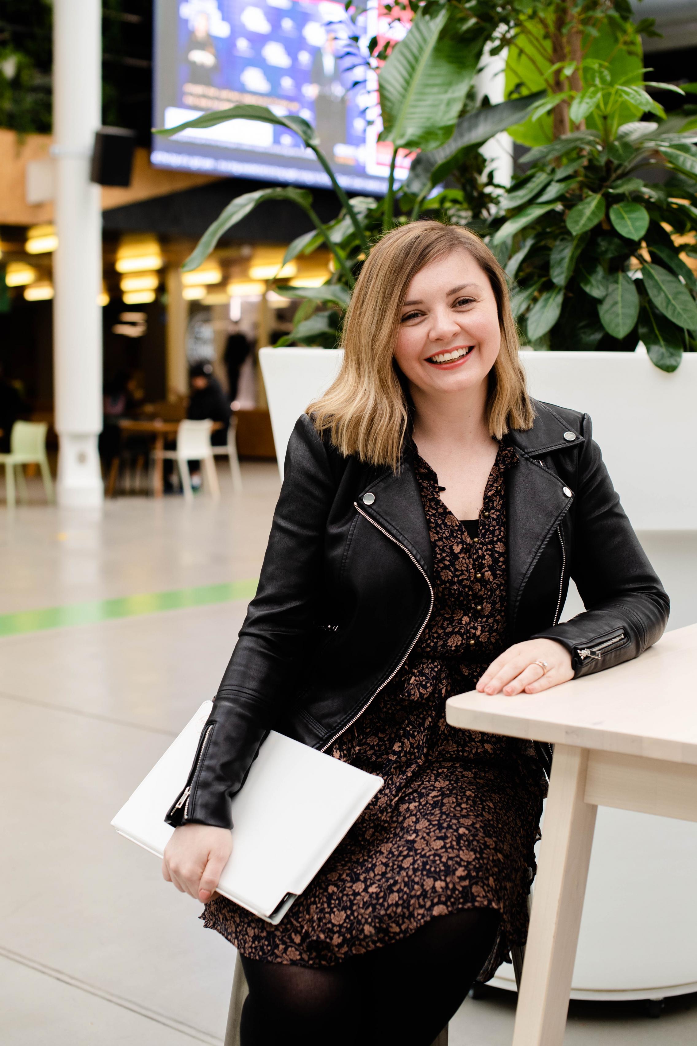 Image of Amelia sitting at a bench in the University of Adelaide Hub.