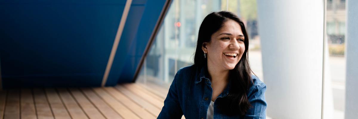 Image of Neha sitting at a desk with a textbook