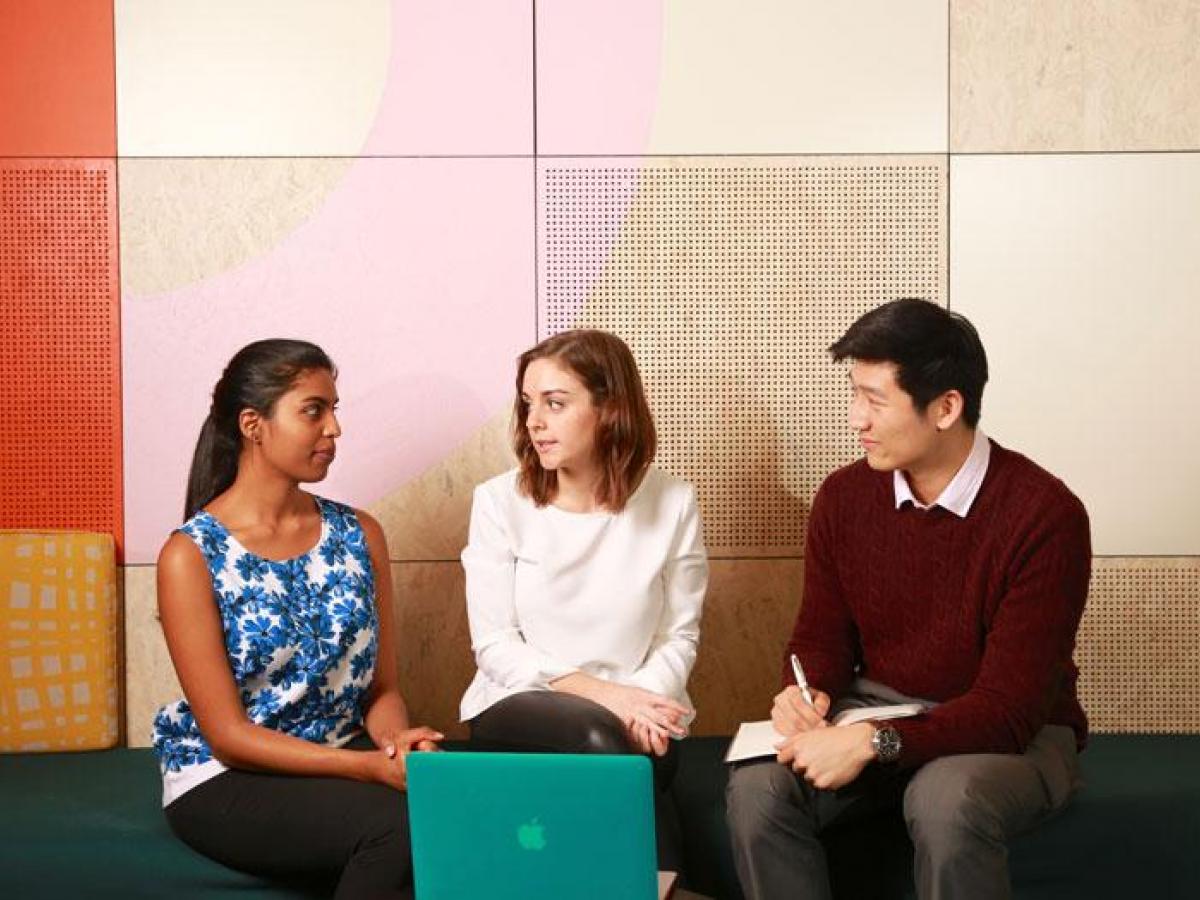 Three students sitting and chatting