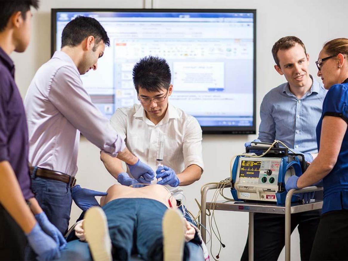 Medicine students working on a simulated patient