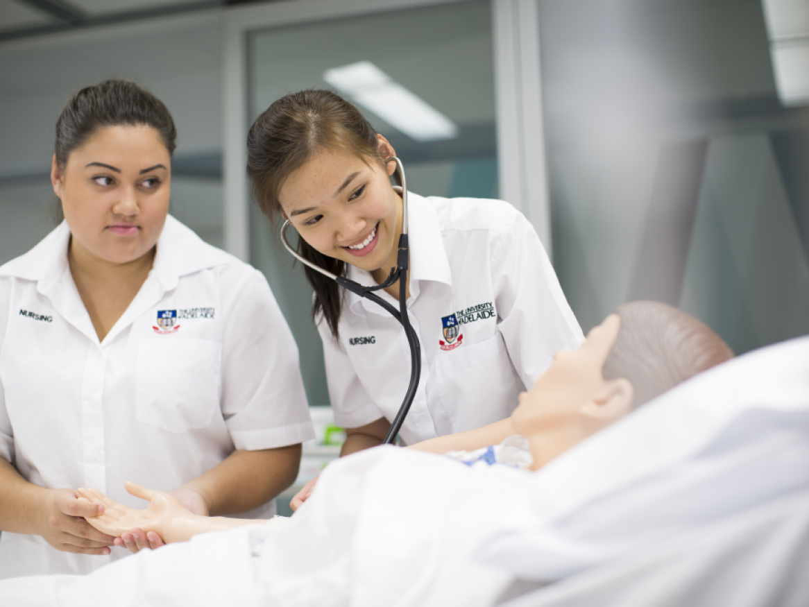 Two nursing students assessing simulated patient